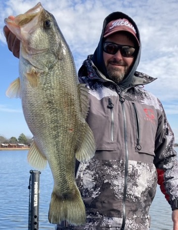 Angler holding a big largemouth bass on the water